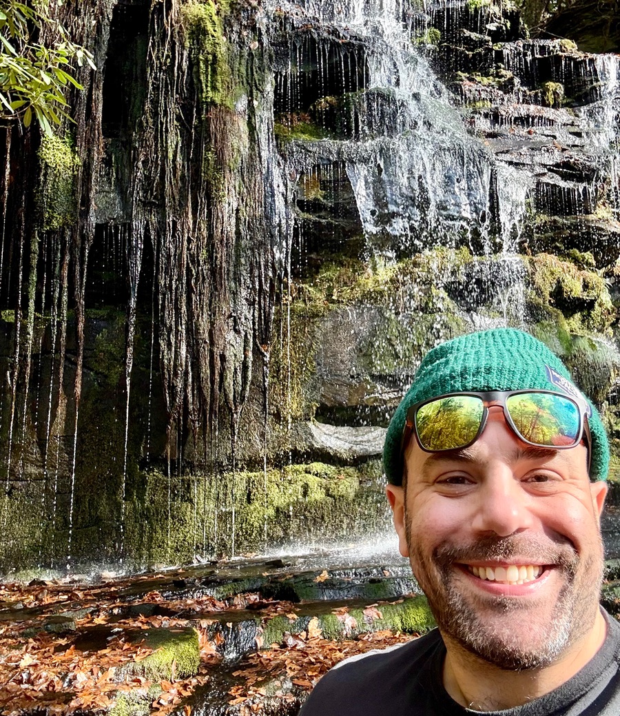 Evan, BCBA and founder of Cove ABA, standing outdoors in a forest setting