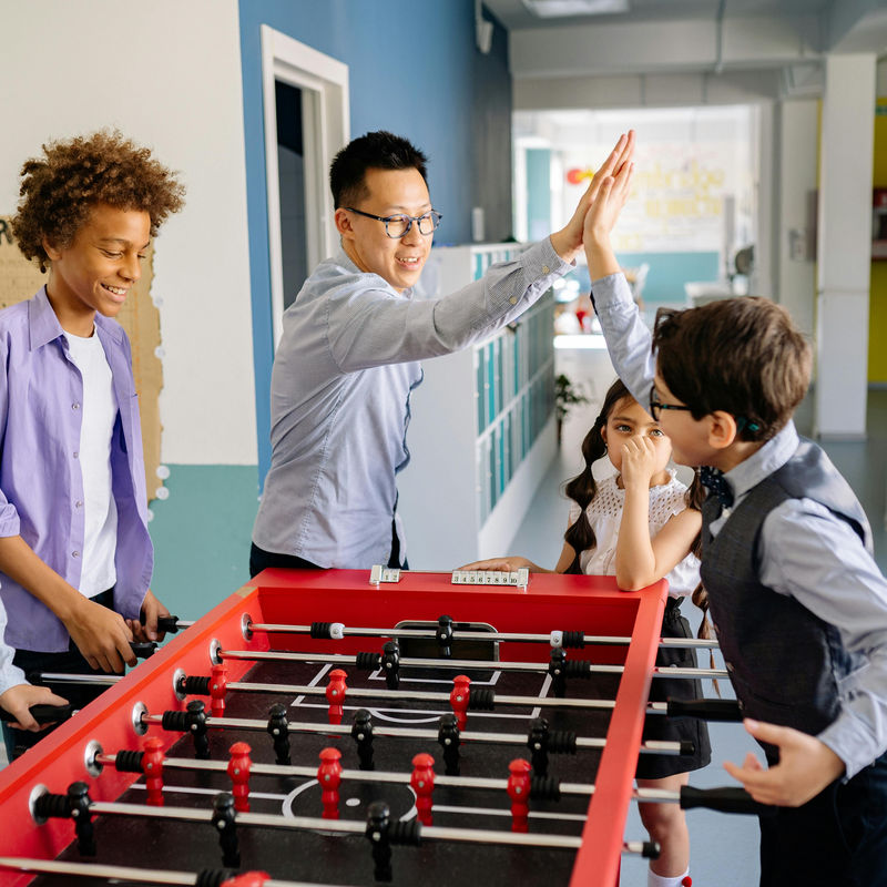 Children playing together and building social skills with an adult nearby